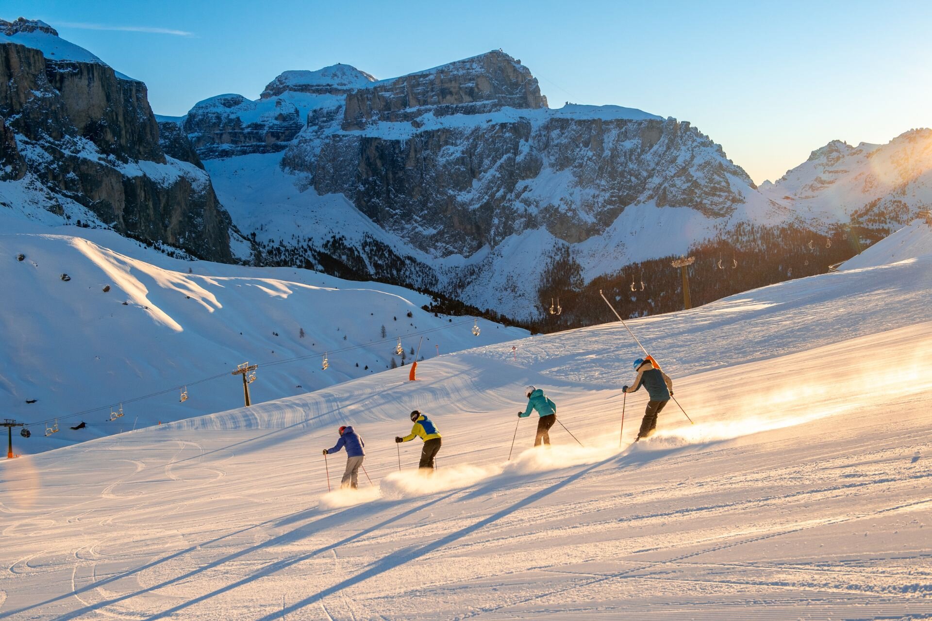 Trentino Ski Sunrise in Val di Fassa | © Archivio Immagini ApT Val di Fassa - Mattia Rizzi Quattro persone sciano all'aba sulle piste della Val di Fassa con vista sul Pordoi | © Archivio Immagini ApT Val di Fassa - Mattia Rizzi