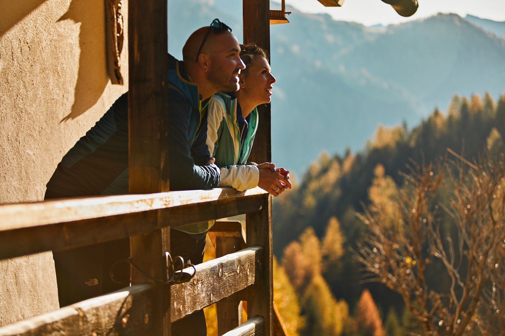 Autunno in Val di Fassa | © Fulvio Maiani Coolpixel - Archivio Immagini APT Val di Fassa Persone che ammirano il paesaggio autunnale da un balcone in legno in Val di Fassa | © Fulvio Maiani Coolpixel - Archivio Immagini APT Val di Fassa
